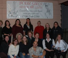 A group of people poses in front of a sign that reads "Pour Gires and Some Guys" outdoors at night.