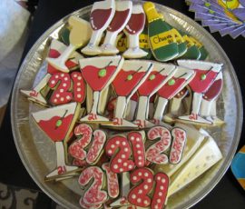 A platter of decorated cookies shaped like martinis, wine glasses, bottles, and the number 21.