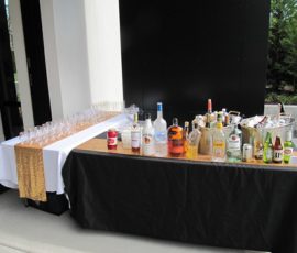 A table with bottles and glasses.