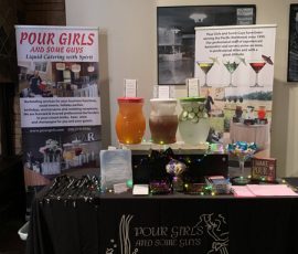 A vendor booth for "Pour Girls and Some Guys" displays beverage dispensers, promotional signs, and branded materials.